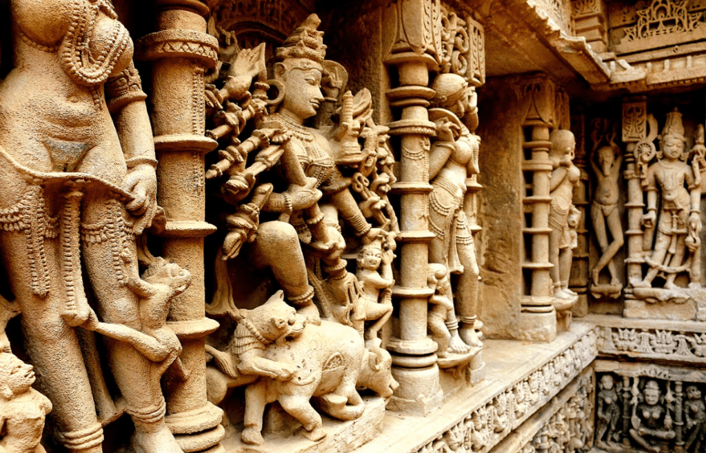 रानी की वाव की दीवारों पर उकेरी गई विष्णु और अप्सरा प्रतिमाएँ